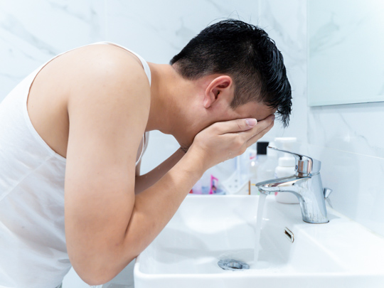 Man Cleansing his face