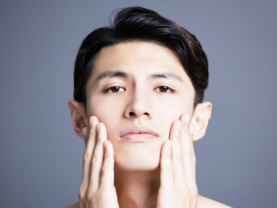 man moisturizing his face