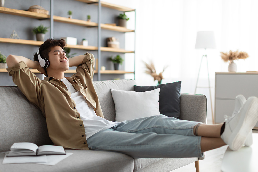 man destresses on the couch while listening to music